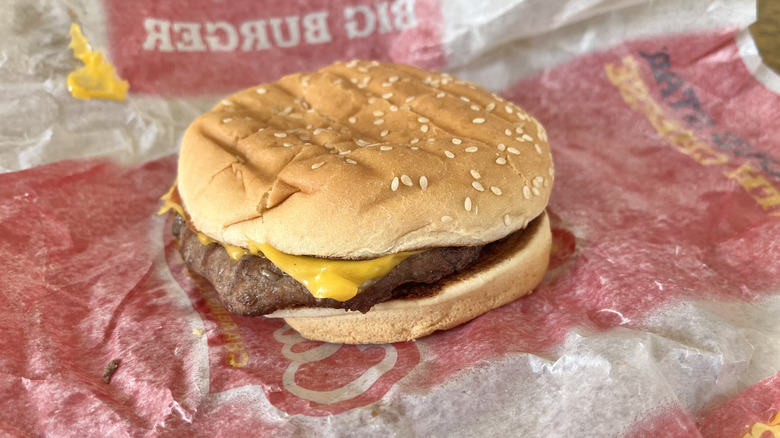 Close up of a Carl's Jr. Big Cheeseburger with a paper wrapper