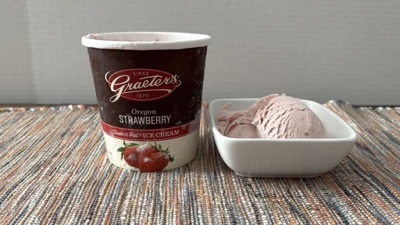 Graeter's strawberry ice cream in carton and bowl on neutral placemat