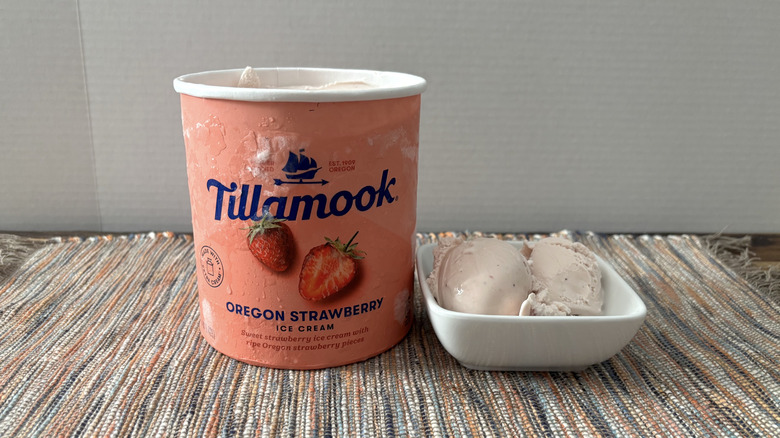 Tillamook strawberry ice cream in carton and bowl on neutral placemat