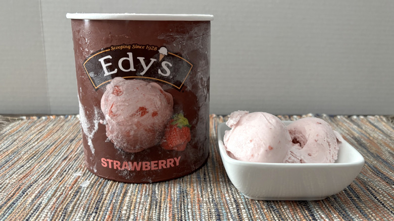 Edy's strawberry ice cream in carton and bowl on neutral placemat