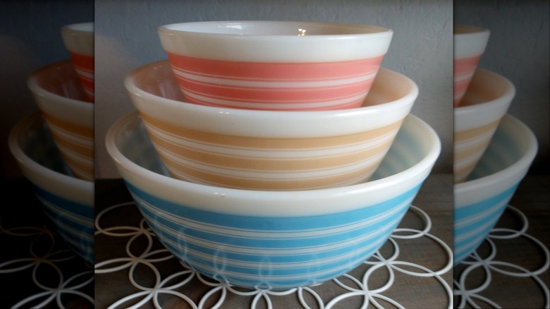 Three Pyrex Rainbow Stripes mixing bowls in pink, tan, and blue stacked inside each other