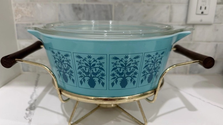 Pyrex casserole dish with lid, featuring Saxony or Tree of Life pattern on warming cradle