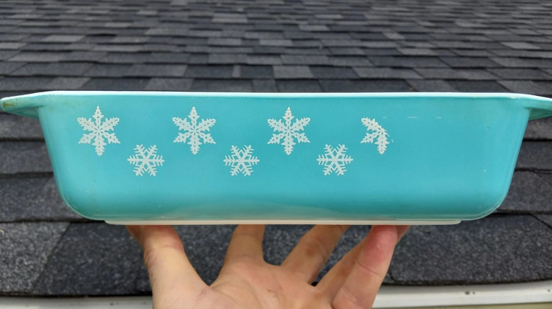 A turquoise Pyrex casserole dish in a white Snowflake pattern