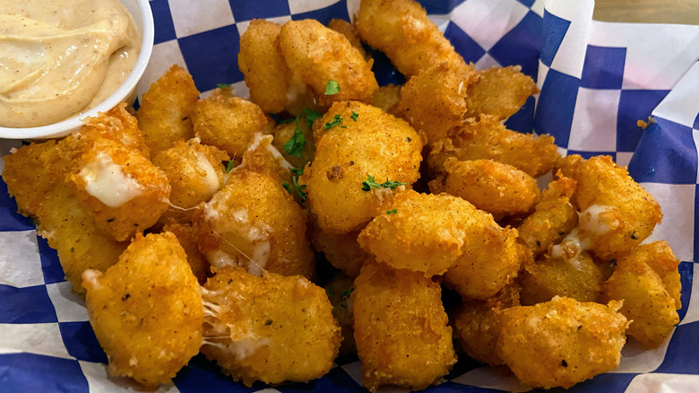 Fried cheese curds sitting in blue and white checked paper