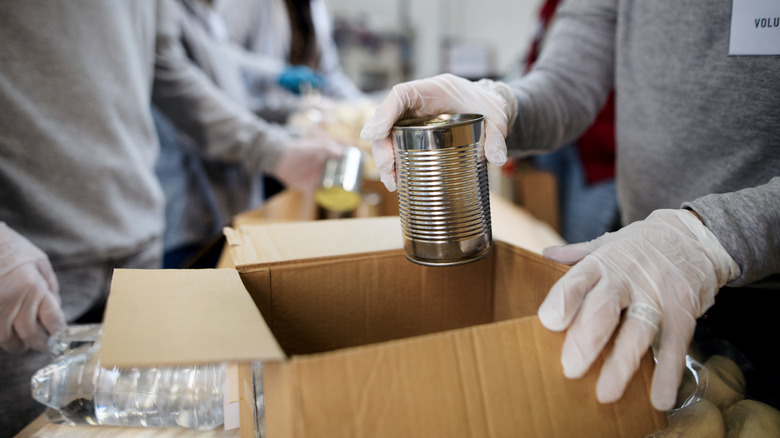 person packing canned food donations