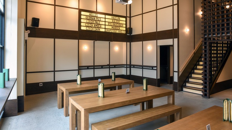 Inside of a brewery with tables and a beer list