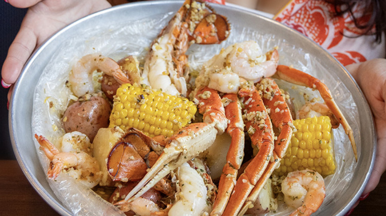 Closeup of customer holding plate of Red Lobster seafood boil