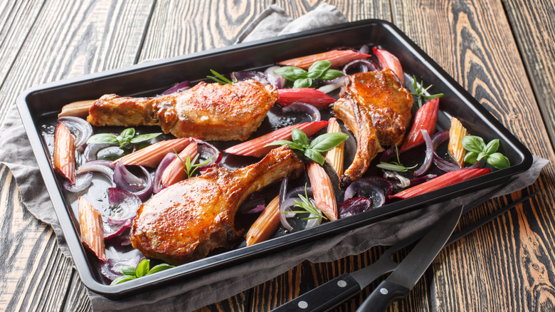Baked and glazed pork chops on tray with vegetables