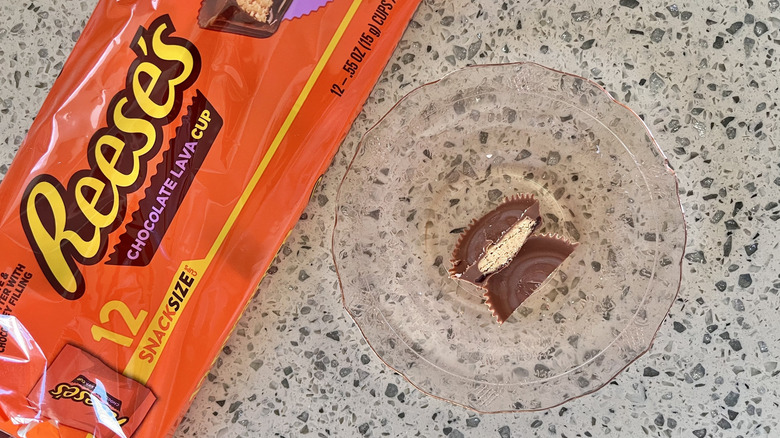 split Reese's Chocolate Lava Cup on dish beside candy wrapper