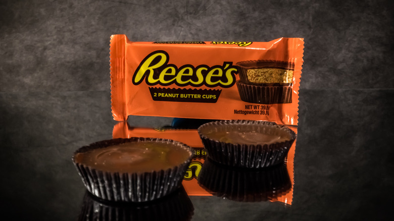 Reese's milk chocolate peanut butter cups on a gray background.