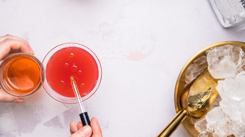 Adding oil to cocktail glasses.