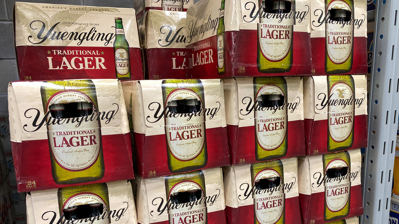 Packs of Yuengling Traditional Lager stacked high in a liquor store