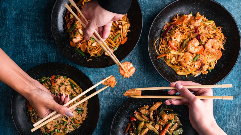 diners eating Chinese food with chopsticks