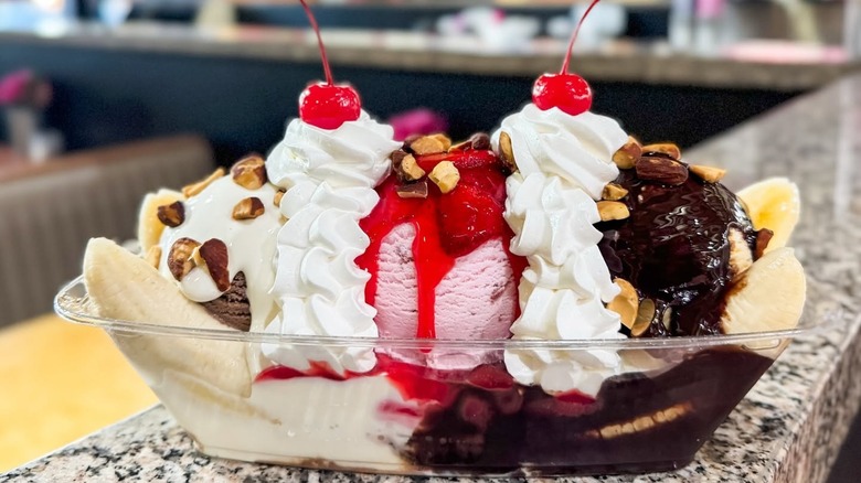 Banana split with cherries and whipped cream on counter