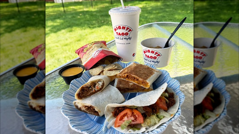 Plate of assorted burritos from mighty Taco with drink and sides
