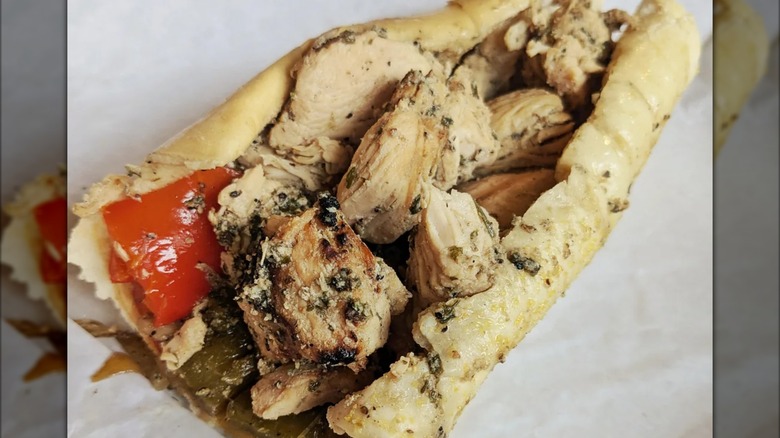 Chicken speidie on paper with peppers and onions