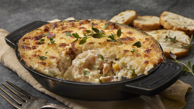 Clam pie in cast iron skillet served with crusty bread