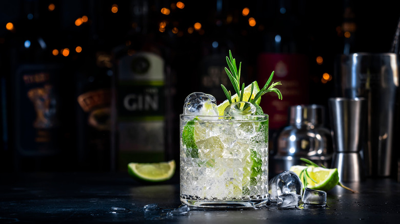 Gin fizz cocktail with limes on bar