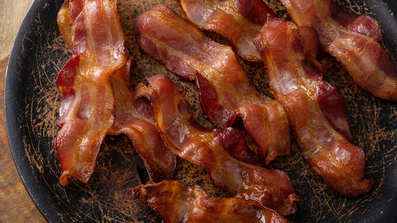 Cooked bacon slices on a textured plate