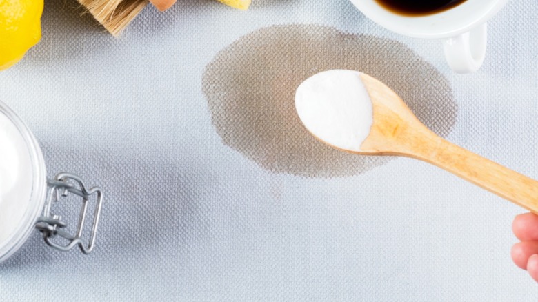 Baking powder in a spoon to treat a grease stain
