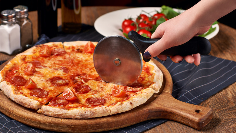 Cutting pizza with pizza cutter