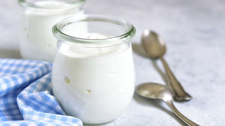 Two glass yogurt jars with spoons, napkin