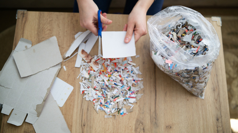 person cutting up shreds of plastic for a pillow