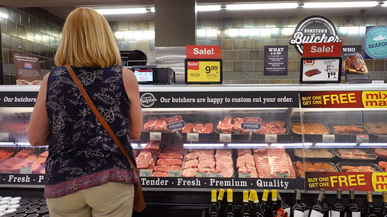Woman looking at meats 