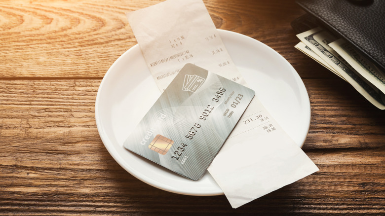 Person paying a bill at a restaurant with card