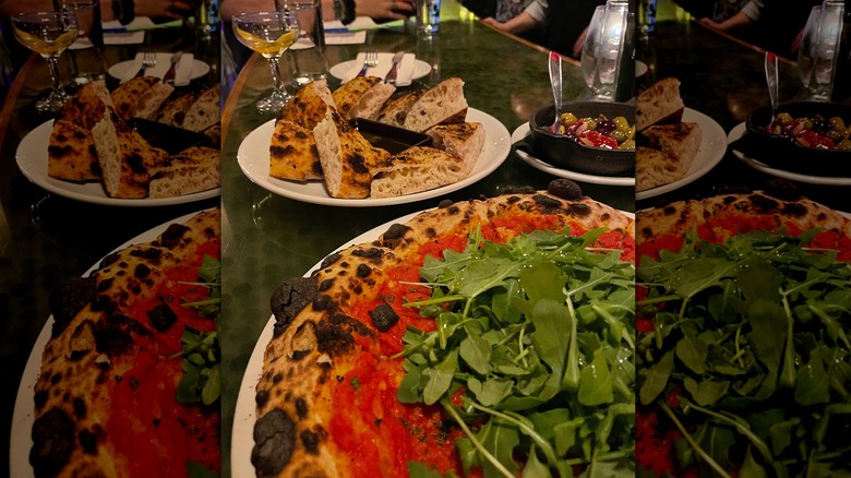 Arugula-topped pizza on a bar