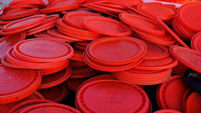 pile of red plastic lids