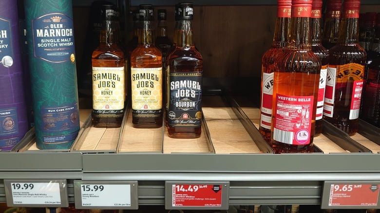A picture of an Aldi shelf showing both the usual and reduced price of Samuel Joe's bourbon