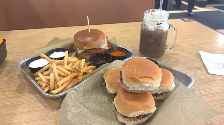 Buffalo Wild Wings sliders, chicken sandwich, fries, sauces on tray, drink behind