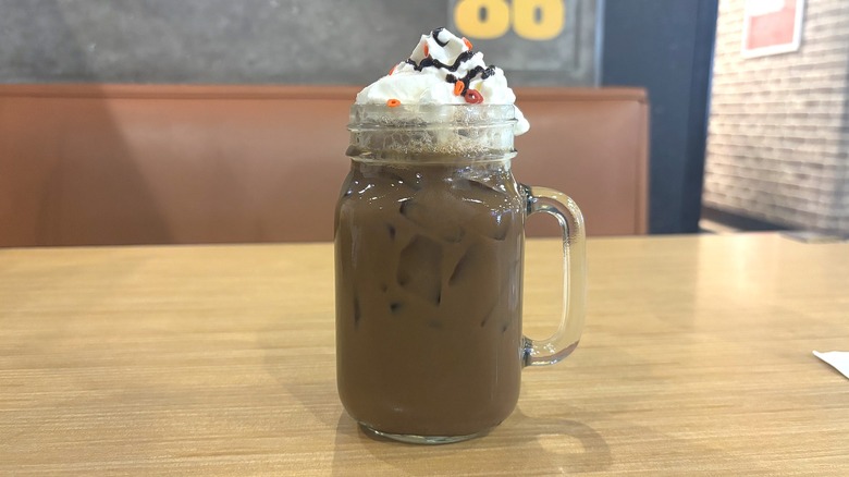 Boozy Dunkin' Cold Brew in handle jar on wooden table at Buffalo Wild Wings