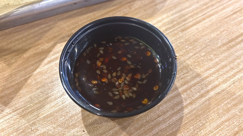 Close-up of Sweet Chili Crisp sauce on wooden table at Buffalo Wild Wings