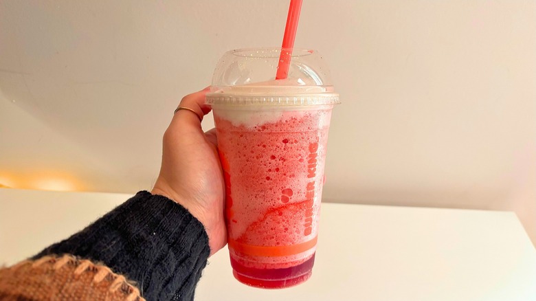 Hand holding Burger King Frozen Strawberries & Cream over white table