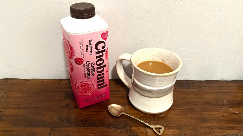 Chobani Raspberry Rose coffee creamer next to a cup of coffee