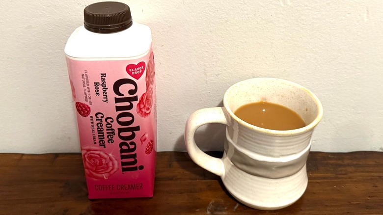 Chobani Raspberry Rose coffee creamer next to a cup of coffee