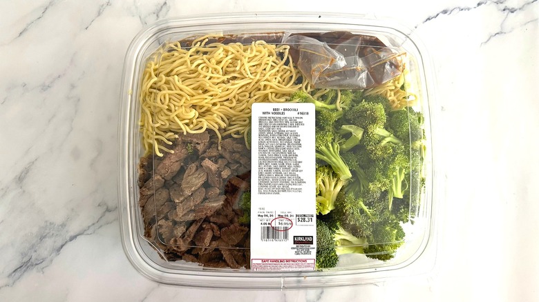 Top-down shot of package of Costco beef and broccoli on marble surface