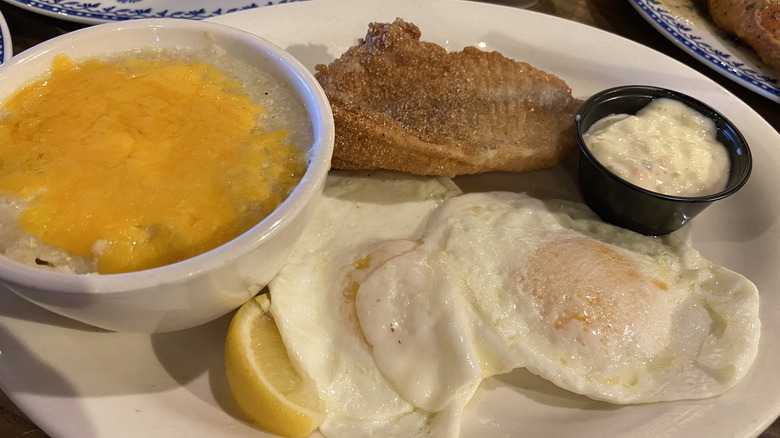Plate with eggs, lemon, tartar sauce, cheese grits, fried catfish