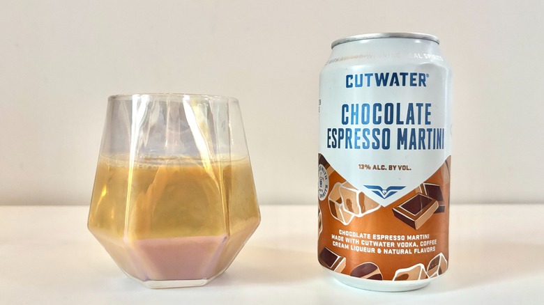Glass with chocolate espresso martini next to Cutwater chocolate espresso martini can on table