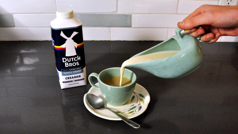 Pouring creamer into coffee