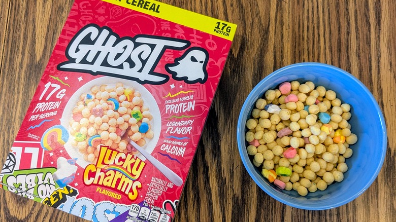 A box and bowl of Lucky Charms-flavored Ghost protein cereal on a wood table