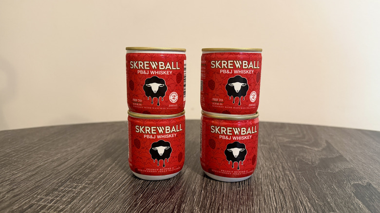 Four stacked cans of Skrewball whiskey