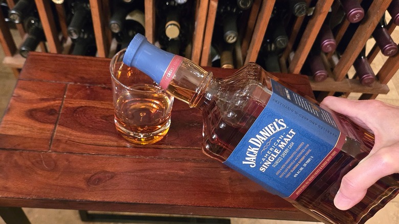 Pouring Jack Daniel's American Single Malt into rocks glass