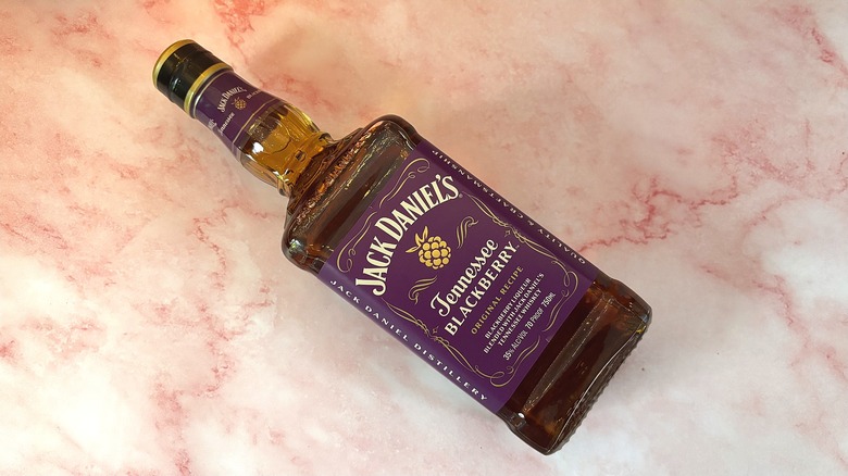 Top-down view of bottle of Jack Daniel's Tennessee Blackberry Whiskey on pink marbled surface