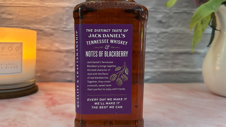 Side label with descriptor of Jack Daniel's Tennessee Blackberry Whiskey on bottle of whiskey