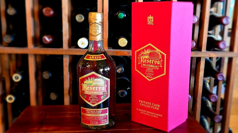 Bottle and box of Reserva de la Familia Private Cask Edition No. 2: Mole Edition in front of a wooden bottle rack