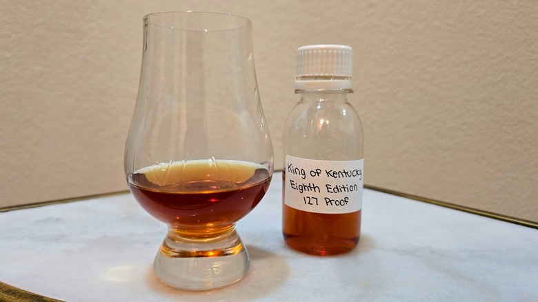 Sample bottle of King of Kentucky's limited-edition 2025 expression bourbon alongside Glencairn glass