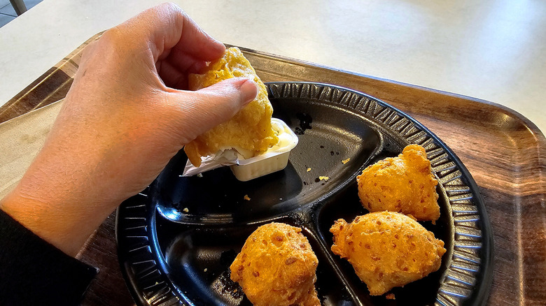 Hand dipping chicken tender into ranch dressing